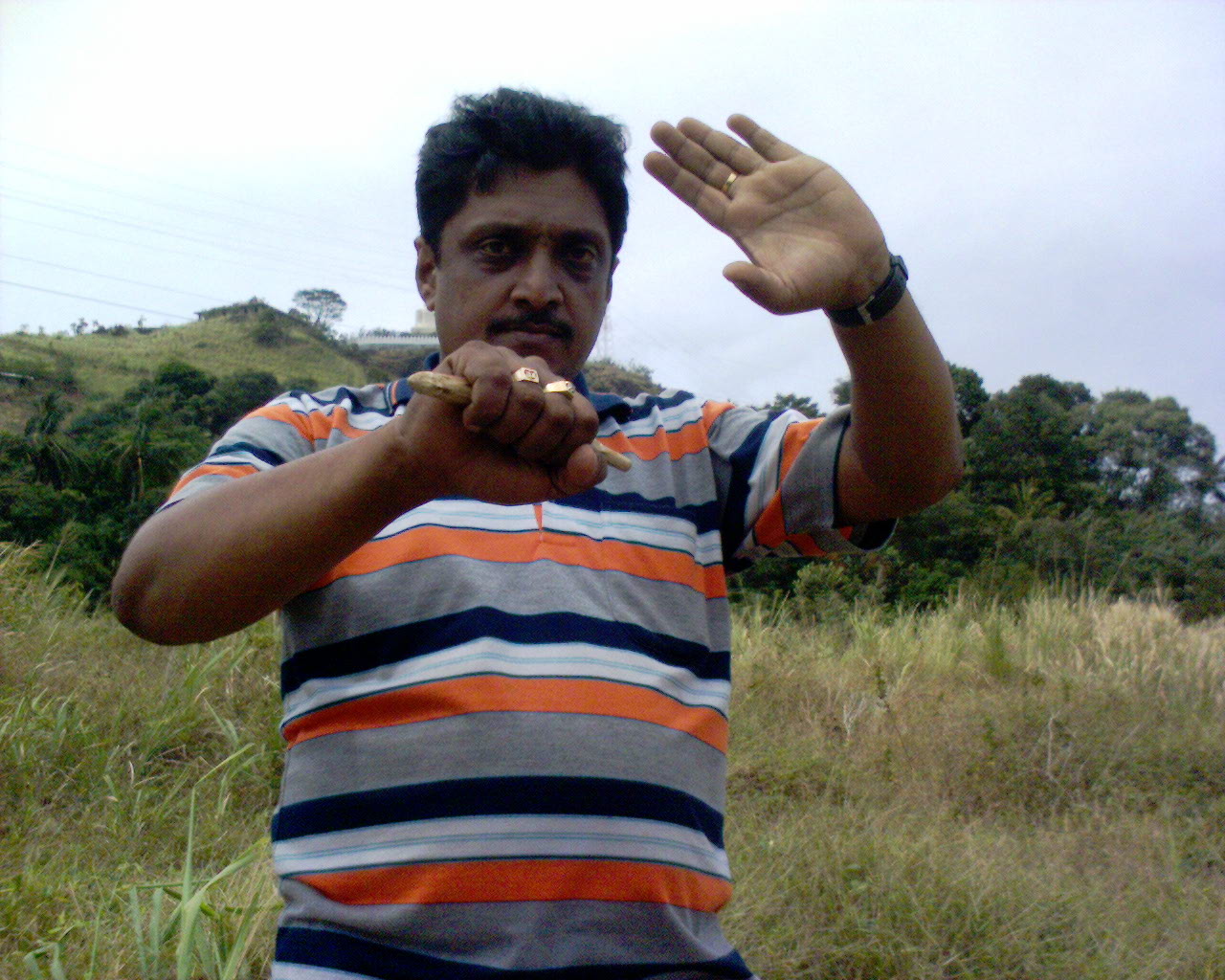 Performing Marma-vadi attack, in background is  Buddha temple at Balangoda